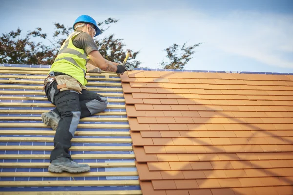 A roofer laying tiles